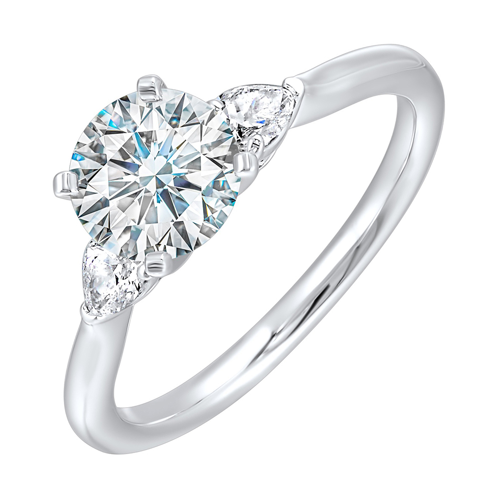 Stunning engagement ring features a round brilliant cut diamond in the center of a three stone setting, adorned on either side by a smaller pear diamond set on the tapered shank.