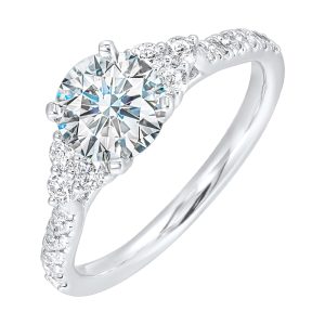 A trio of round diamonds on either side of the solitaire followed by a diamond studded shank, this ring is sure to impress her.