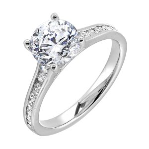 The simplicity of this single row channel set diamond shank engagement ring with four prong solitaire is simply gorgeous.